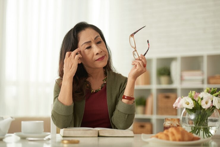 a woman taking her glasses off