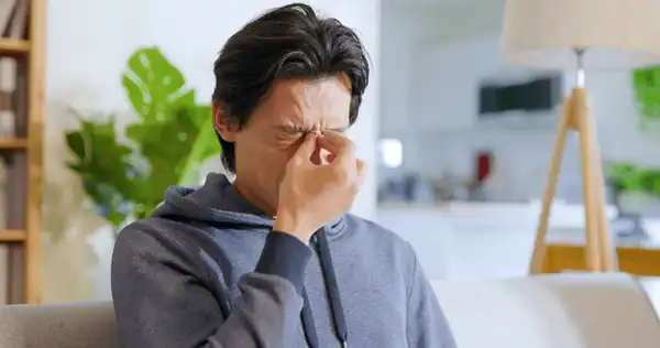 asian man rubbing his eyes
