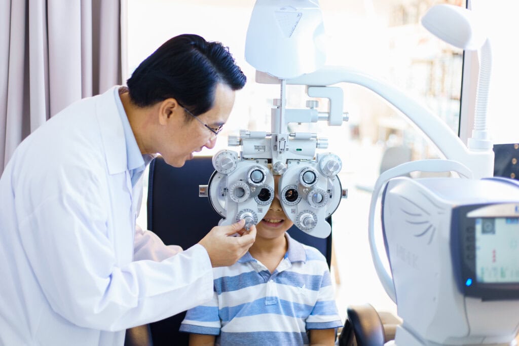 an ophthalmologist doing eye check up to a young boy