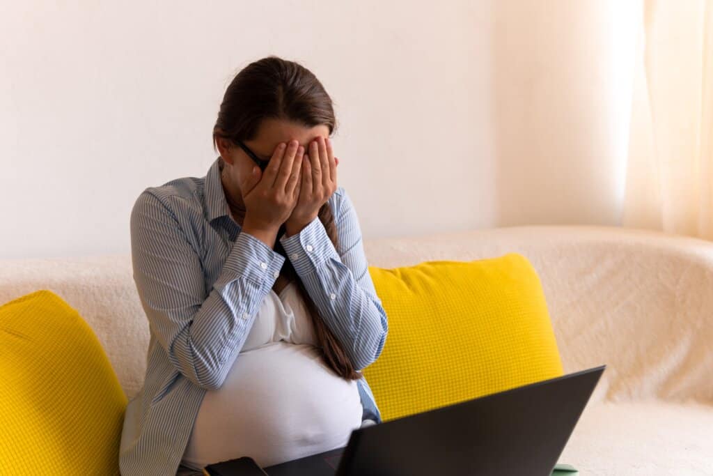 a stressed pregnant woman with glasses