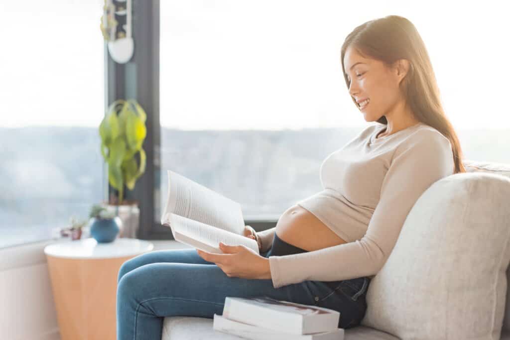 a pregnant woman reading a book