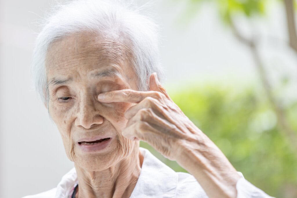 a senior woman rubbing her eyes