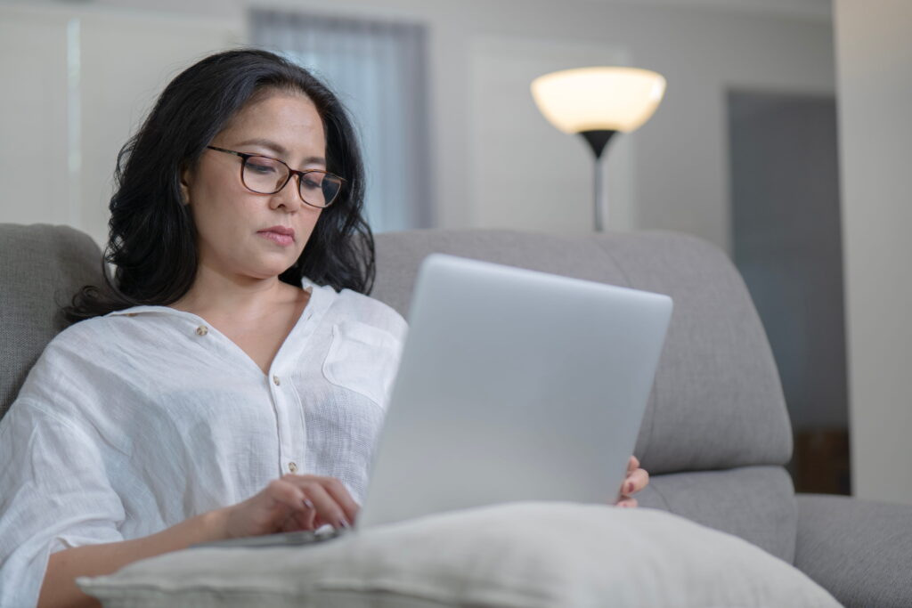 a working woman wearing glasses while using her laptop