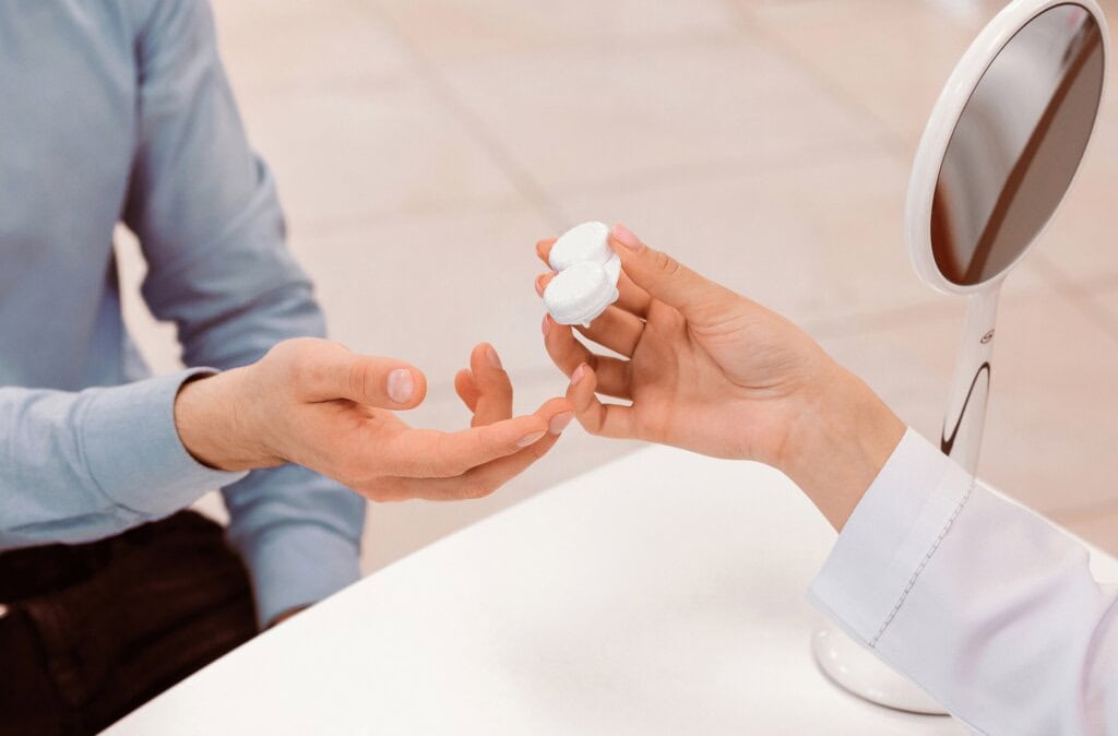 a patient is handed a contact lens case by an eye care professional